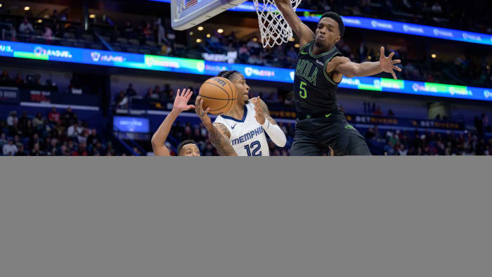 Memphis Grizzlies guard Ja Morant goes up against New Orleans Pelicans guard CJ McCollum.
